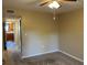 Bedroom view with neutral walls and carpet, ceiling fan and glimpses of other rooms, such as kitchen at 730 S Village N Dr # 101, St Petersburg, FL 33716