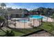Aerial view of two fenced community pools, lounge chairs and the surrounding condominium complex at 730 S Village N Dr # 101, St Petersburg, FL 33716