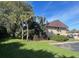Well-kept condo exterior with green lawn and lush trees under blue skies at 730 S Village N Dr # 101, St Petersburg, FL 33716