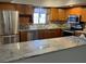 Updated kitchen with stainless steel appliances, granite counters, and tile backsplash at 730 S Village N Dr # 101, St Petersburg, FL 33716