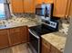 Kitchen featuring stainless steel appliances, granite counters, and wood cabinets at 730 S Village N Dr # 101, St Petersburg, FL 33716