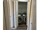 Updated laundry room with modern washer and dryer units, shelving, and bi-fold doors at 730 S Village N Dr # 101, St Petersburg, FL 33716