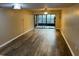 Open living room featuring hardwood flooring and sliding door to screened patio at 730 S Village N Dr # 101, St Petersburg, FL 33716