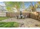 Backyard patio with a table and chairs, surrounded by a wooden fence and lush greenery at 7301 S Swoope St, Tampa, FL 33616