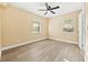 Bedroom with light wood flooring, ceiling fan, and natural light from two windows at 7301 S Swoope St, Tampa, FL 33616