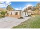 Side angle of home with stone accents, showing a large driveway and well-kept lawn at 7301 S Swoope St, Tampa, FL 33616