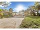 Wide front view of a one-story home with stone detailing, surrounded by trees and a spacious front yard at 7301 S Swoope St, Tampa, FL 33616