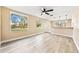 Open-concept living area with light wood floors, large windows, and a view into the kitchen area at 7301 S Swoope St, Tampa, FL 33616