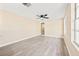 Spacious living room featuring light wood flooring, a ceiling fan, and natural light from large windows at 7301 S Swoope St, Tampa, FL 33616