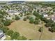 Aerial view of a neighborhood park featuring green spaces, playground, and basketball court surrounded by trees at 7326 Blue Beech Dr, Riverview, FL 33578