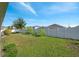 Large backyard with green grass and a white fence with landscaping around the perimeter at 7326 Blue Beech Dr, Riverview, FL 33578