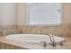 Bathroom featuring a soaking tub with chrome fixtures and tiled surround at 7326 Blue Beech Dr, Riverview, FL 33578