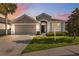 Beautifully landscaped home exterior with a manicured lawn, a two car garage, and neutral paint at 7326 Blue Beech Dr, Riverview, FL 33578
