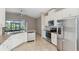 Open kitchen with stainless steel appliances, white cabinetry and granite countertops at 7326 Blue Beech Dr, Riverview, FL 33578