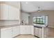 Kitchen boasts granite counters, white cabinets, stainless steel appliances, and a ceiling fan at 7326 Blue Beech Dr, Riverview, FL 33578