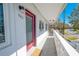 View of condo's outdoor space with balcony, a red door, and well-maintained white railings at 8325 112Th St # 202, Seminole, FL 33772