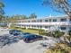 A view of the condo building with ample parking, trimmed hedges, and a well-kept lawn at 8325 112Th St # 202, Seminole, FL 33772