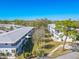 Serene exterior view of the apartment complex with lush green spaces and mature trees under clear blue sky at 8325 112Th St # 202, Seminole, FL 33772