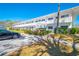 Two-story apartment exterior featuring red door accents, white railing, and mature landscaping at 8325 112Th St # 202, Seminole, FL 33772