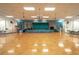 Spacious hall featuring a hardwood floor and a stage with blue curtains at 8325 112Th St # 202, Seminole, FL 33772