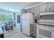 Eat-in kitchen features white appliances, grey cabinets, and dining area with ample light at 8325 112Th St # 202, Seminole, FL 33772