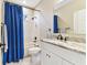 Bathroom featuring a single sink vanity with a marble countertop and a shower with a blue shower curtain at 8837 Garden Party Dr, Land O Lakes, FL 34637