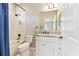 Bathroom featuring a tub-shower combo with a blue curtain and a vanity with a marble countertop and white cabinets at 8837 Garden Party Dr, Land O Lakes, FL 34637