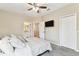 Bedroom featuring a ceiling fan, carpeted floor, TV mounted on the wall and access to the bathroom and hallway at 8837 Garden Party Dr, Land O Lakes, FL 34637