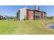 Exterior of condo building from a grassy slope with lake view with lots of green space in a waterfront community at 9100 Dr Martin Luther King Jr N St # 405, St Petersburg, FL 33702