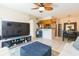 Living room with open kitchen, ceiling fan, tile floors, dining area, and large screen television at 9100 Dr Martin Luther King Jr N St # 405, St Petersburg, FL 33702