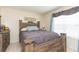Bedroom with a rustic wood bed, large window with curtains, and tile flooring at 9100 Dr Martin Luther King Jr N St # 405, St Petersburg, FL 33702