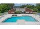 A stunning view of the large, sparkling pool and lounge area with a red brick recreation building at 9100 Dr Martin Luther King Jr N St # 405, St Petersburg, FL 33702