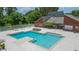 A stunning view of the large, sparkling pool and lounge area with a red brick recreation building at 9100 Dr Martin Luther King Jr N St # 405, St Petersburg, FL 33702