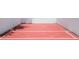 Outdoor racquetball court with red surface and white boundary lines, surrounded by white walls, offers a space for recreation at 9100 Dr Martin Luther King Jr N St # 405, St Petersburg, FL 33702