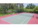 A full view of the fenced tennis court surrounded by trees and greenery at 9100 Dr Martin Luther King Jr N St # 405, St Petersburg, FL 33702