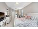 Comfortable bedroom with white furniture, a patterned bedspread, and natural light from the windows at 10014 Vista Pointe Dr, Tampa, FL 33635