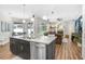 Open-concept kitchen flows into the living room featuring stainless appliances, stone countertops and hardwood floors at 10014 Vista Pointe Dr, Tampa, FL 33635