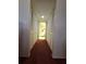 Hallway featuring closet space on either side and a view of a bathroom at the end of the hall at 1010 Bowsprit Ln # 0, Holiday, FL 34691