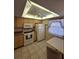 Cozy kitchen featuring neutral cabinetry, white appliances, and a tile floor at 1010 Bowsprit Ln # 0, Holiday, FL 34691