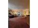 Spacious living room with plush carpeting, comfortable seating, and a view into the dining area at 1010 Bowsprit Ln # 0, Holiday, FL 34691