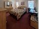 Comfortable main bedroom featuring a bed, dresser, mirror, and a dedicated workspace at 1010 Bowsprit Ln # 0, Holiday, FL 34691