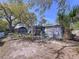 Wide shot of backyard with chairs, mature trees, and a partially visible house at 10128 114Th N Ter, Largo, FL 33773