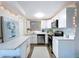 Updated kitchen boasts white cabinets, stainless steel appliances, and bright lighting at 10128 114Th N Ter, Largo, FL 33773