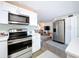Open kitchen view showcasing stainless appliances, white cabinetry, and seamless transition to the living area at 10128 114Th N Ter, Largo, FL 33773