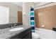 Bathroom featuring a granite countertop, a mirror, and a shower-tub combo with blue curtains at 11432 Leland Groves Dr, Riverview, FL 33579