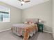 The bright bedroom features a ceiling fan, a large window, and colorful decor at 11432 Leland Groves Dr, Riverview, FL 33579