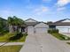 Well-maintained house showcasing a spacious driveway and landscaping, including mature palm trees at 11432 Leland Groves Dr, Riverview, FL 33579