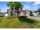 Charming home with lush green lawn, mature palm trees, three-car garage and stone accents at 11432 Leland Groves Dr, Riverview, FL 33579