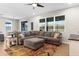 Comfortable living room featuring a sectional sofa, ceiling fan, and bright windows at 11432 Leland Groves Dr, Riverview, FL 33579