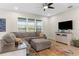 Bright living room featuring a large sectional sofa, colorful rug, and ample natural light at 11432 Leland Groves Dr, Riverview, FL 33579